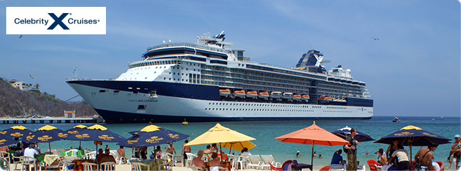 Ship docked at sea and people chilling under different coloured umbrellas by the beach