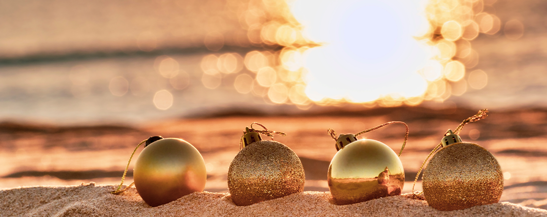 Holiday ornaments on beach at sunset